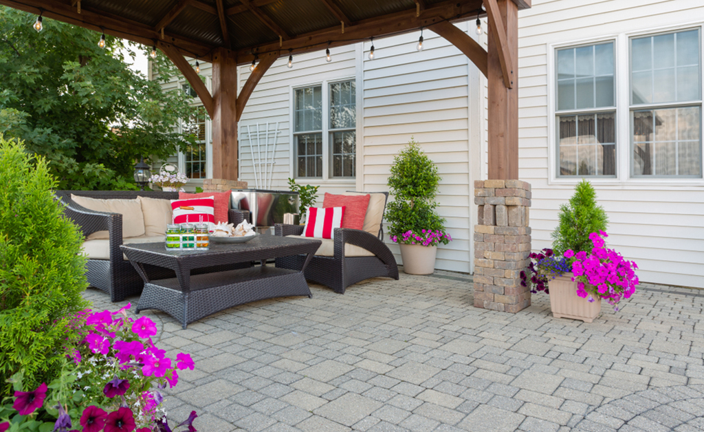 exterior patio and summer living space with a covered gazebo, colorful petunias and comfortable seating